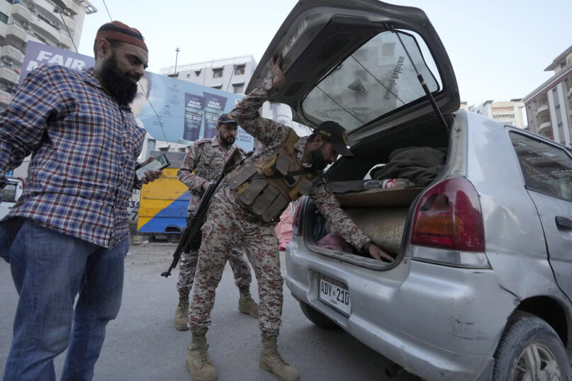 Paramilitary soldiers search a car at a temporary checkpoint on a road in Karachi, Pakistan, Tuesday, April 9, 2024. Pakistani authorities have deployed more than 100,000 police and paramilitary forces at mosques and marketplaces across the country ahead of the massive Eid al-Fitr holiday, officials said. (AP Photo/Fareed Khan)