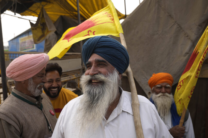 Farmers celebrate news of the repeal of farm laws they were protesting against, in Singhu, on the outskirts of New Delhi, Nov. 19, 2021. Prime Minister Narendra Modi said his government will withdraw the controversial farm laws that were met with yearlong demonstrations from millions of farmers who said the laws would shatter their livelihoods. (AP Photo/Manish Swarup)