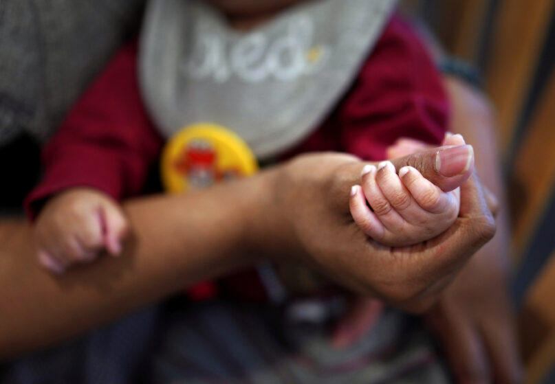 Jasmine Heriot, a former Mary's Shelter resident, holds her infant's hand on Friday, January 5, 2024, in Fredericksburg, Virginia. In the two years since the Supreme Court overturned Roe v. Wade and the federal right to abortion, there has been a nationwide expansion of maternity homes. Today there are more than 450 homes in the U.S., many of them faith-based. (AP Photo/Jessie Wardarski)