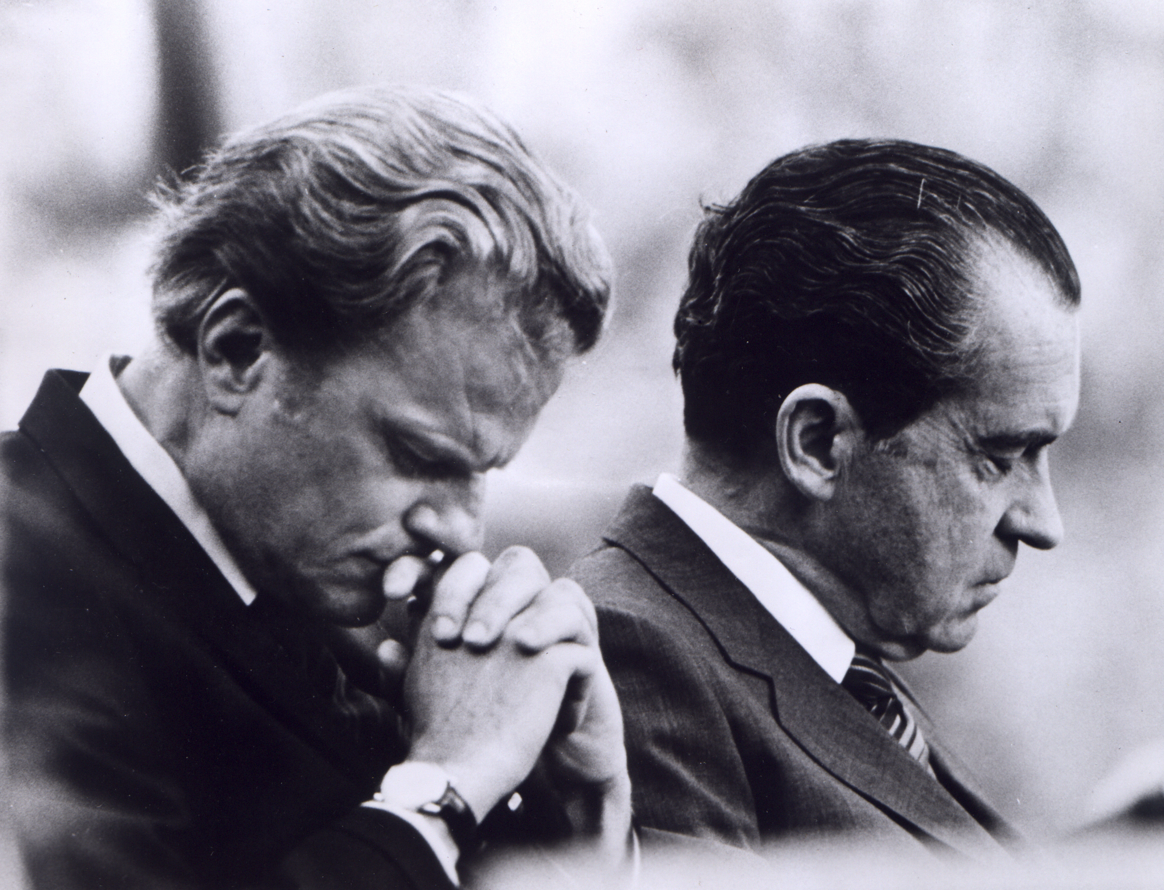 RNS GRAHAM: Knoxville, Tenn. -- President Richard M. Nixon (right) and Billy Graham bow their heads in prayer during the President's visit to the Billy Graham East Tennessee Crusade at Knoxville, Tenn.Religion News Service file photo. 1970