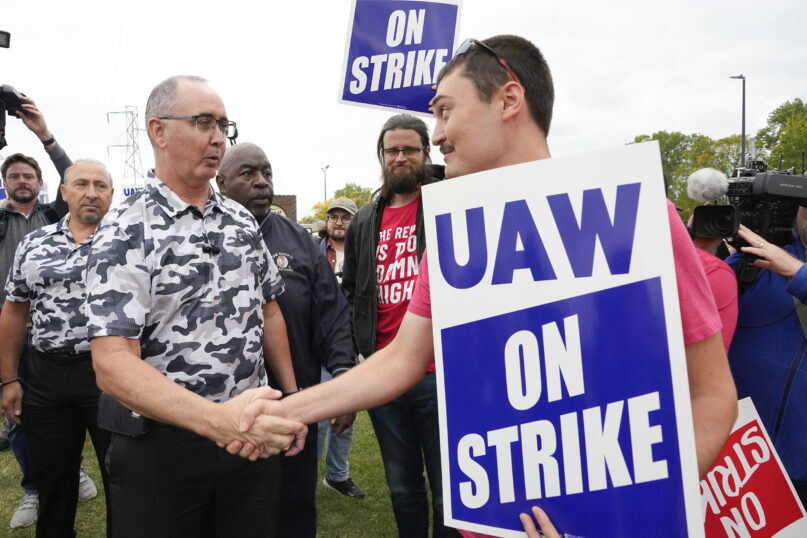 United Auto Workers President Shawn Fain, left, talks with members picketing near a General Motors assembly plant in Delta Township, Mich., Sept. 29, 2023.  (AP Photo/Paul Sancya)