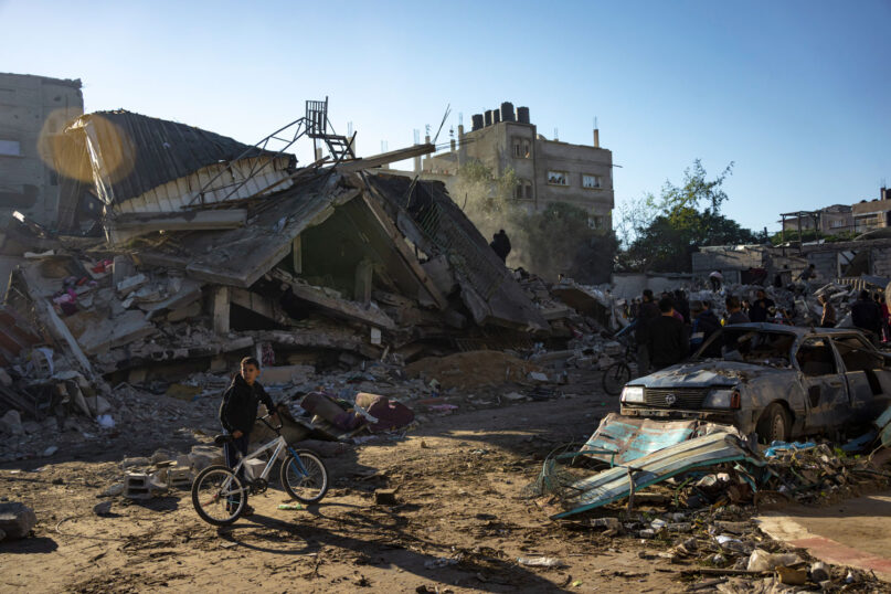 Palestinians search for bodies and survivors in the rubble of a residential building destroyed in an Israeli airstrike, in Rafah, southern Gaza Strip, Friday, Dec. 15, 2023. (AP Photo/Fatima Shbair)