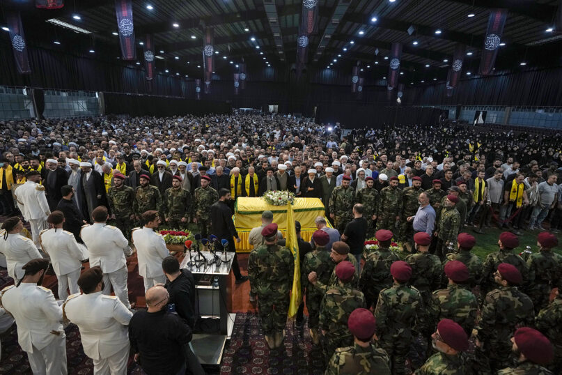 Mourners pray over the coffin of senior commander Mohammad Naameh Nasser, who was killed by an Israeli airstrike that hit his car in the southern coastal town of Tyre, during his funeral procession in the southern suburbs of Beirut, Lebanon, Thursday, July 4, 2024. The strike took place as global diplomatic efforts have intensified in recent weeks to prevent escalating clashes between Hezbollah and the Israeli military from spiraling into an all-out war that could possibly lead to a direct confrontation between Israel and Iran. (AP Photo/Bilal Hussein)