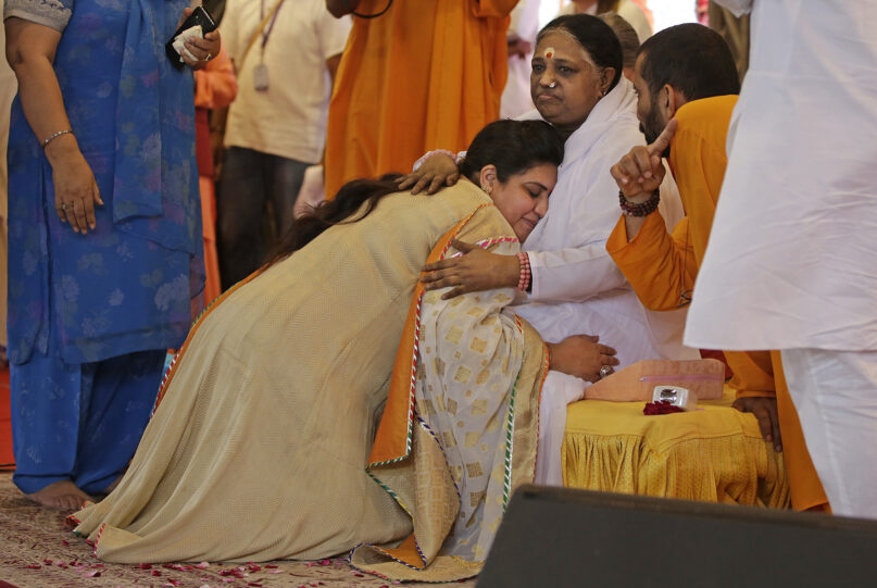 Indian spiritual leader Mata Amritanandamayi, seated right, hugs a devotee during a prayer meeting in New Delhi, March 16, 2018. Known among her followers as “Amma,” which means “mother” in several Indian languages, Amritanandamayi has devotees in India and the rest of the world. She is also popularly known as the Hugging Saint. (AP Photo/Altaf Qadri)