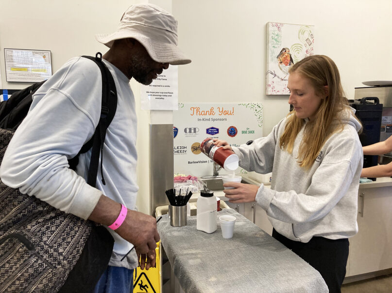 Anne Bazemore, right, of Raleigh, volunteered serving coffee to men experiencing homelessness who flocked to Oak City Cares, a nonprofit in downtown Raleigh North Carolina. The 25-year-old is a member of Imago Dei Church, a Southern Baptist congregation. RNS photo by Yonat Shimron