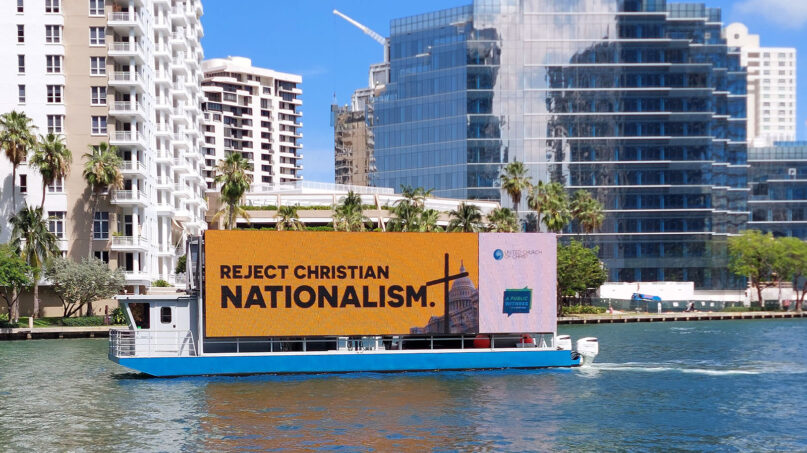 A boat billboard sponsored by a coalition of groups opposed to Christian nationalism travels around downtown Miami in May 2023 during a ReAwaken America Tour stop. (Photo courtesy Faithful America)