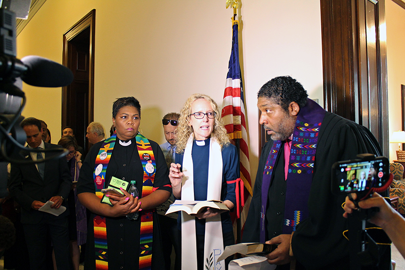 The Rev. Jennifer Butler, center, speaks during a protest against the Republican health care bill outside the office of Senate Majority Leader Mitch McConnell on Capitol Hill in Washington, D.C., on July 13, 2017. RNS photo by Madeleine Buckley