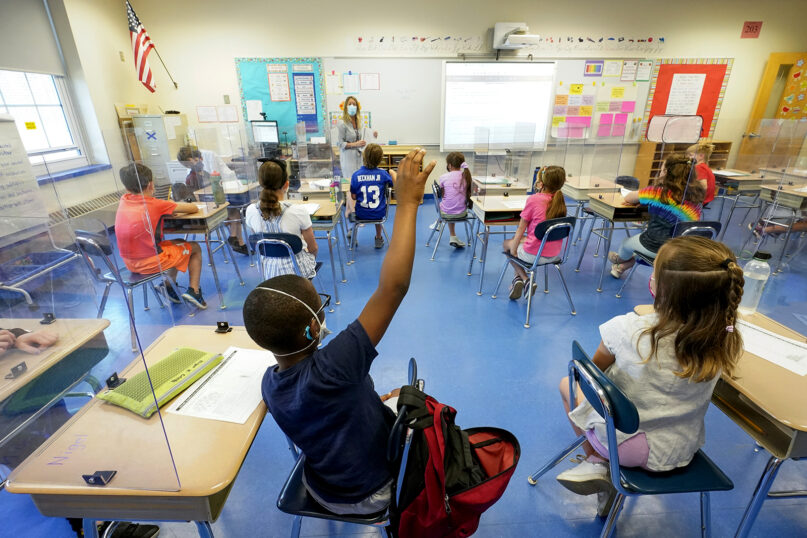 In this May 18, 2021, file photo, a teacher, center, and her third grade students wear face masks and are socially distanced during class in Rye, New York. (AP Photo/Mary Altaffer, File)