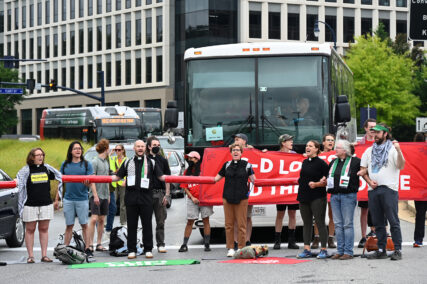 An interfaith group of clergy and other pro-Palestinian protesters blocks buses filled with attendees for the Christians United for Israel summit in National Harbor, Maryland, Tuesday, July 30, 2024. (RNS photo/Jack Jenkins)