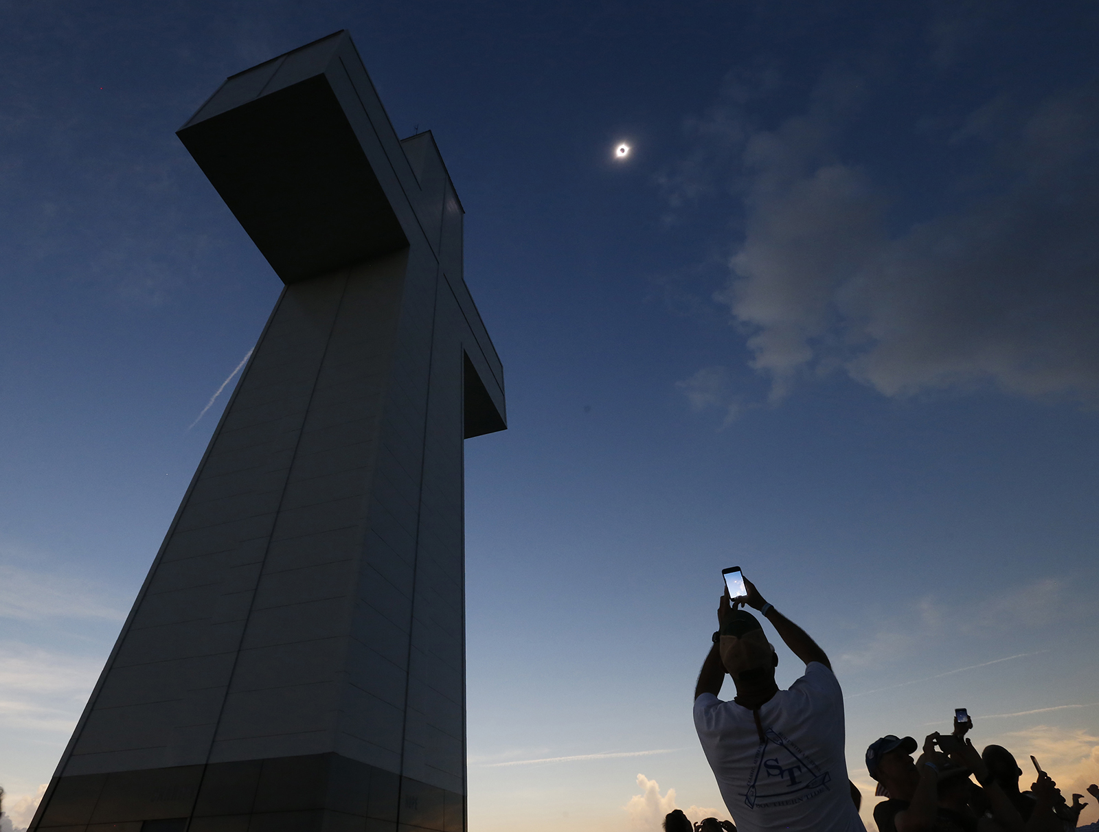 FILE - A total solar eclipse is seen above the Bald Knob Cross of Peace, Monday, Aug. 21, 2017, in Alto Pass, Ill. Small towns and rural enclaves along the path of April’s 2024 total solar eclipse are steeling for huge crowds of sun chasers who plan to catch a glimpse of day turning into dusk in North America. Throughout history, solar eclipses have had profound impact on adherents of various religions around the world. They were viewed as messages from God or spiritual forces, inducing emotions ranging from dread to wonder. (AP Photo/Charles Rex Arbogast, File)