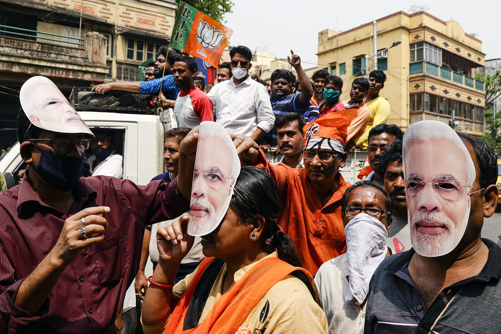 In this March 20, 2021, file photo, supporters of Bharatiya Janata Party wear masks bearing the likeness of Prime Minister Narendra Modi during a campaign rally ahead of elections in West Bengal state in Kolkata, India. Despite clear signs that India was being swamped by another surge of coronavirus infections, Modi refused to cancel the rallies, a major Hindu festival and cricket matches with spectators. The burgeoning crisis has badly dented Modi’s carefully cultivated image as an able technocrat. (AP Photo/Bikas Das, File)