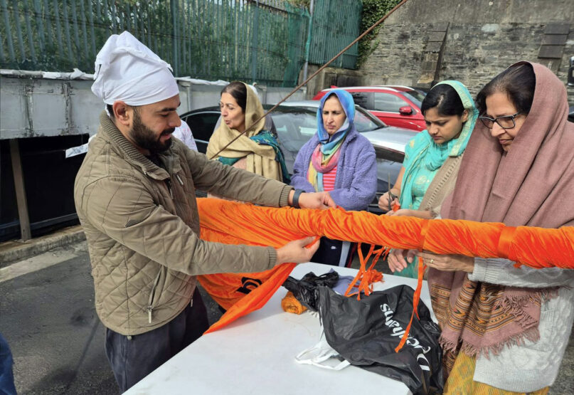 A group of Derry Sikhs prepare the Nishan Sahib flag to be hoisted ahead of the reopening of the Sikh Cultural Centre in Londonderry, Northern Ireland, March 24, 2024. (Photo courtesy Amerjit Singh)