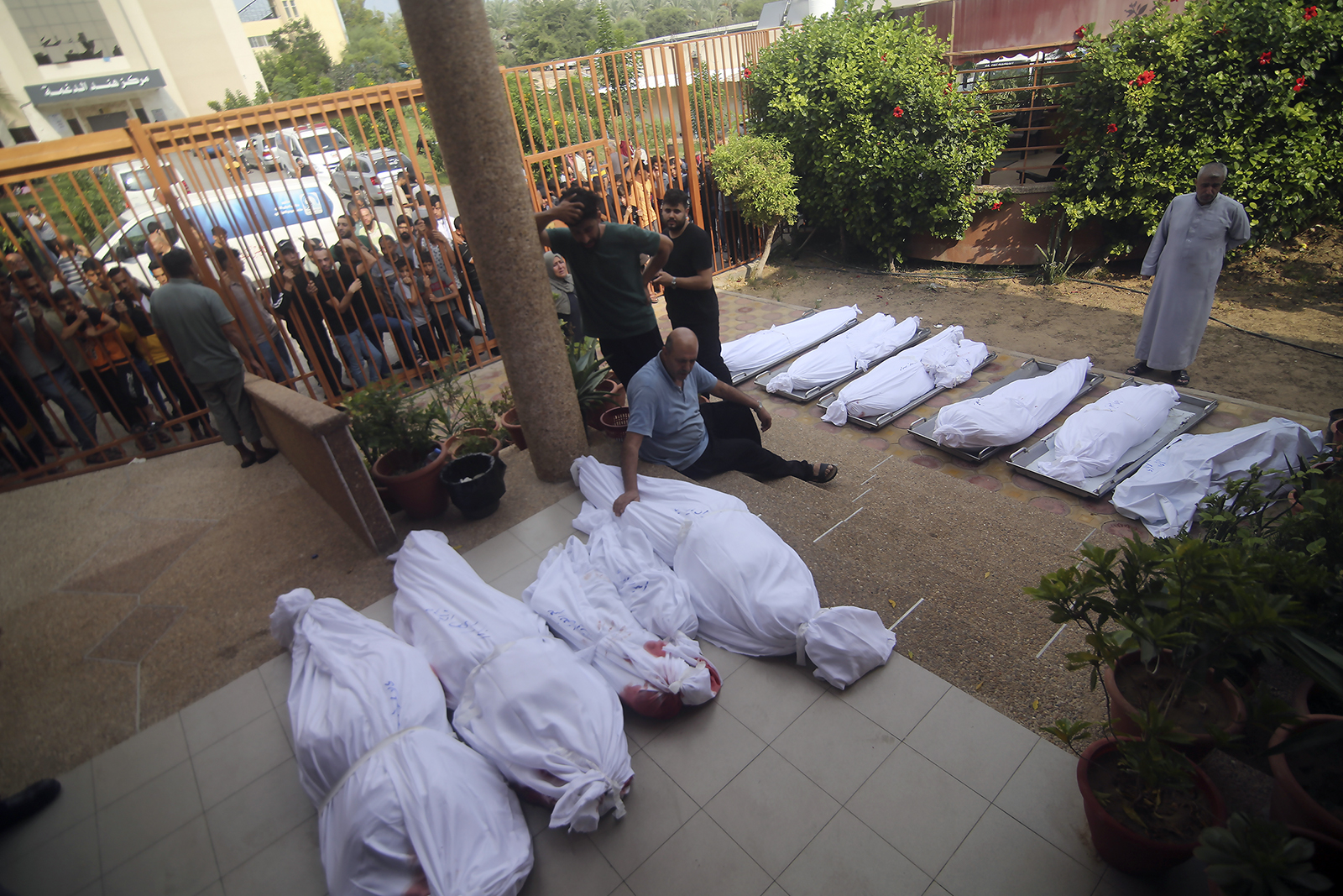 Palestinians gather around the bodies of people killed by Israeli airstrikes during their funeral in Khan Younis, Gaza Strip, Wednesday, Oct. 11, 2023. (AP Photo/Hatem Ali)