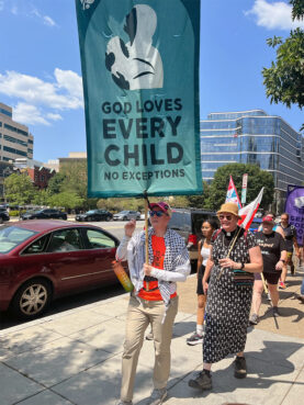 Anna Johnson carries a sign while marching through Washington, D.C., Sunday, July 28, 2024. (RNS photo/Aleja Hertzler-McCain)