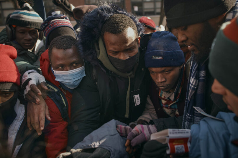 Migrants pick up clothes as mutual aid groups distribute food and clothes under cold weather near the Migrant Assistance Center at St. Brigid Elementary School, on Saturday, Jan. 20, 2024, in New York. (AP Photo/Andres Kudacki)