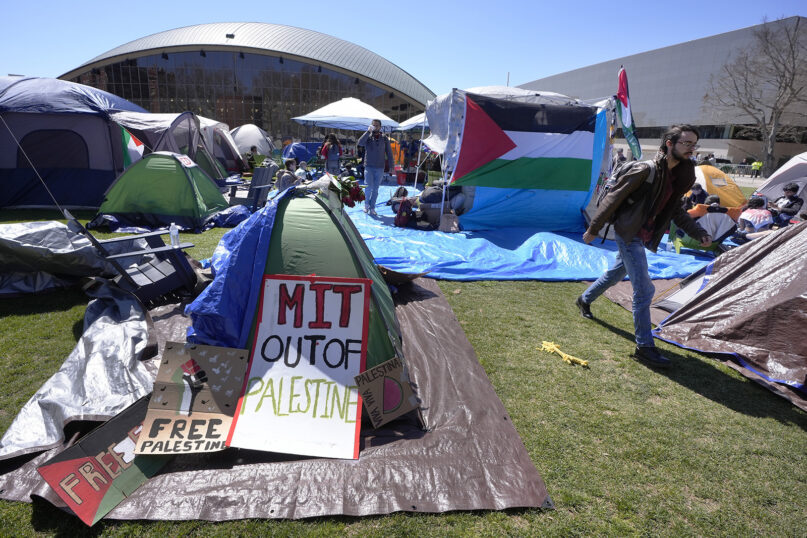 FILE - A passer-by, right, walks through a pro-Palestinian encampment of tents, Thursday, April 25, 2024, on the Massachusetts Institute of Technology campus, in Cambridge, Mass. (AP Photo/Steven Senne, File)