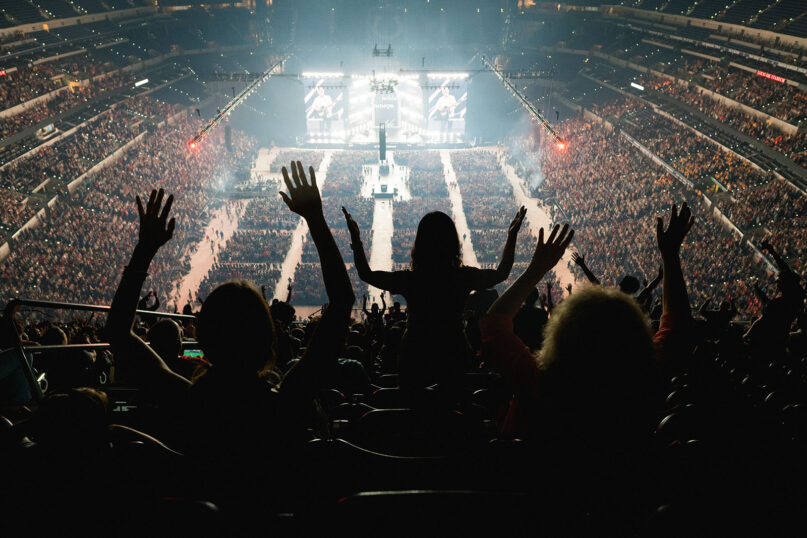 National Eucharistic Congress attendees raise their arms during a song at Lucas Oil Stadium in Indianapolis, July 20, 2024. (Photo by Josh Applegate, in partnership with the National Eucharistic Congress)