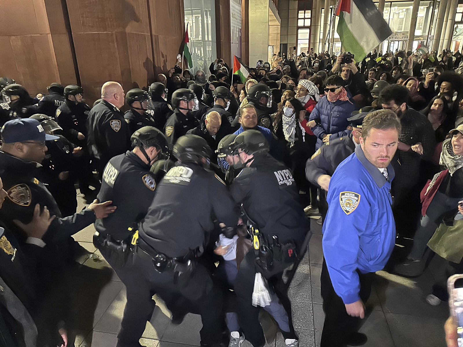 New York City Police Department officers arrest pro-Palestinian protesters outside a student-led encampment at New York University on Monday night, April 22, 2024, in New York. The protest and encampment was set up to demand the university divest from weapons manufacturers and the Israeli government. (AP Photo/Noreen Nasir)