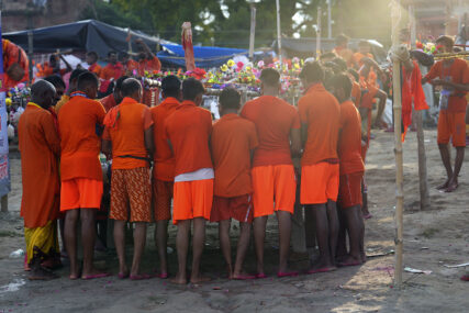 Hindu pilgrims, known as Kanwarias, gather on the banks of the Ganges in Prayagraj, India, Sunday, July 16, 2023. Kanwarias are young men performing a ritual pilgrimage in which they walk, sometimes hundreds of miles, to the Ganges River to take its sacred waters back to Hindu temples in their hometowns. During the Hindu lunar month of Shravana, hundreds of thousands of pilgrims can be seen walking the roads of India, clad in saffron, and carrying ornately decorated canisters of water over their shoulders. (AP Photo/Rajesh Kumar Singh)