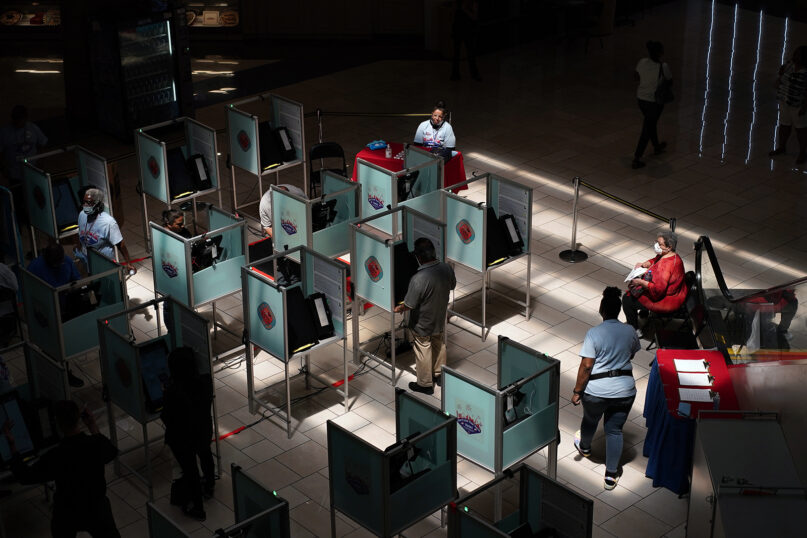 FILE - Workers and voters are pictured at a polling place in Las Vegas, June 14, 2022. (AP Photo/John Locher, File)