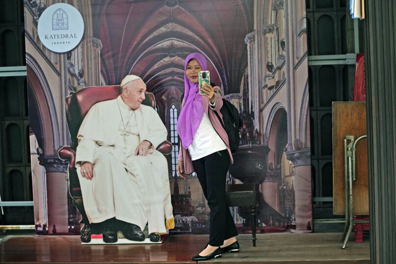 A Muslim woman takes a selfie with a cutout of Pope Francis at The Church of Our Lady of the Assumption, popularly known as the Jakarta Cathedral, in Jakarta, Indonesia, Thursday, Aug. 8, 2024. (AP Photo/Achmad Ibrahim)