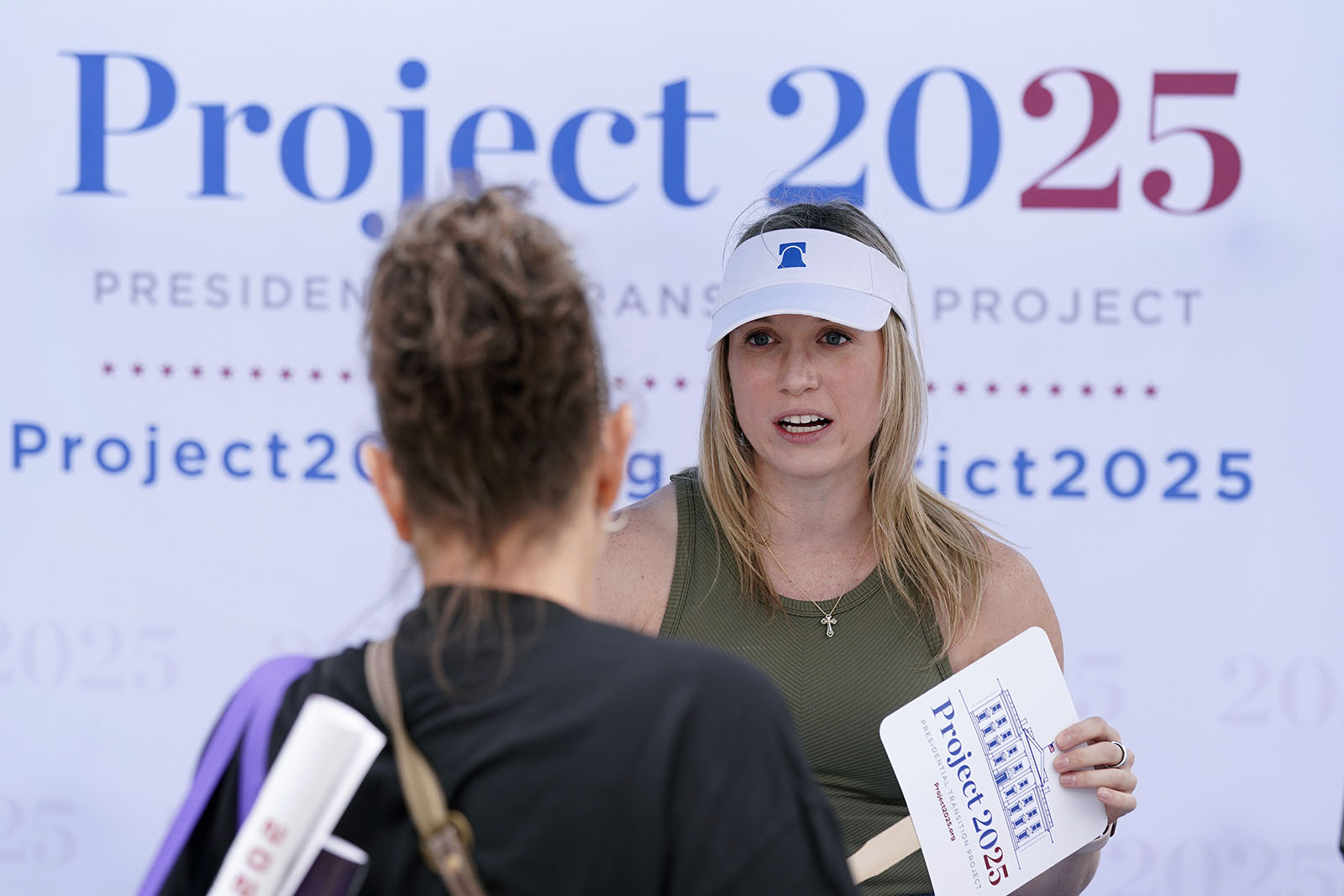 Kristen Eichamer, right, talks to a fairgoer at the Project 2025 tent at the Iowa State Fair, Aug. 14, 2023, in Des Moines, Iowa. The Project 2025 effort is being led by the Heritage Foundation think tank. (AP Photo/Charlie Neibergall)