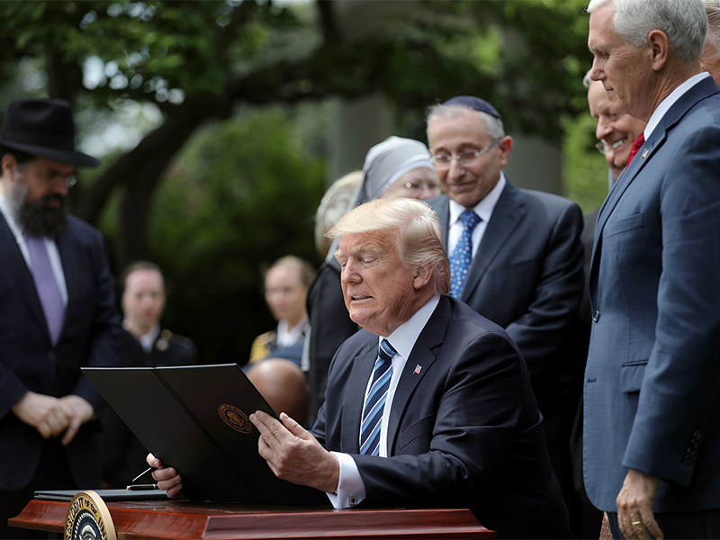 President Trump prepares to sign the Executive Order on Promoting Free Speech and Religious Liberty during the National Day of Prayer event at the Rose Garden of the White House on May 4, 2017. Photo courtesy of Reuters/Carlos Barria