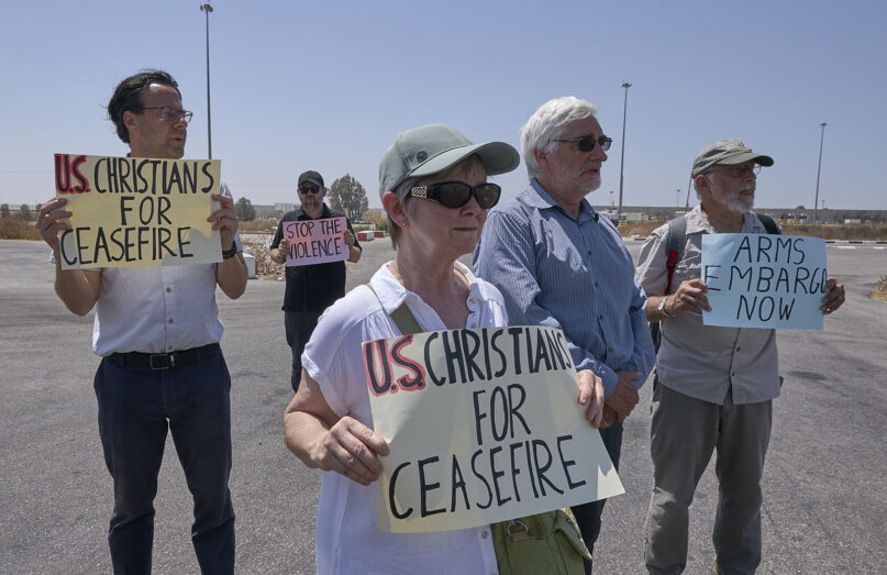 An interfaith delegation holds a prayer vigil at the Kerem Shalom crossing on the border between Israel and Gaza, Aug. 18, 2024. Georgetown University professor Eli McCarthy stands at left.  (Photo © Paul Jeffrey/Life on Earth Pictures)