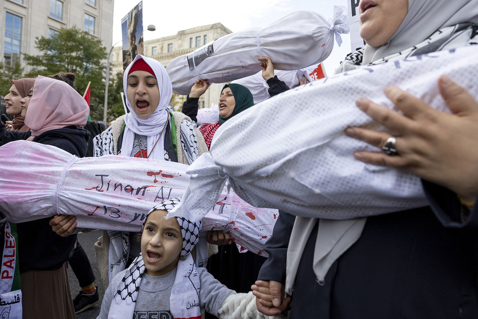 A family that came with the Islamic Center of Union County in New Jersey holds up effigies of Palestinians who were killed by Israel during a pro-Palestinian demonstration in Washington, Saturday, Nov. 4, 2023. (AP Photo/Amanda Andrade-Rhoades)